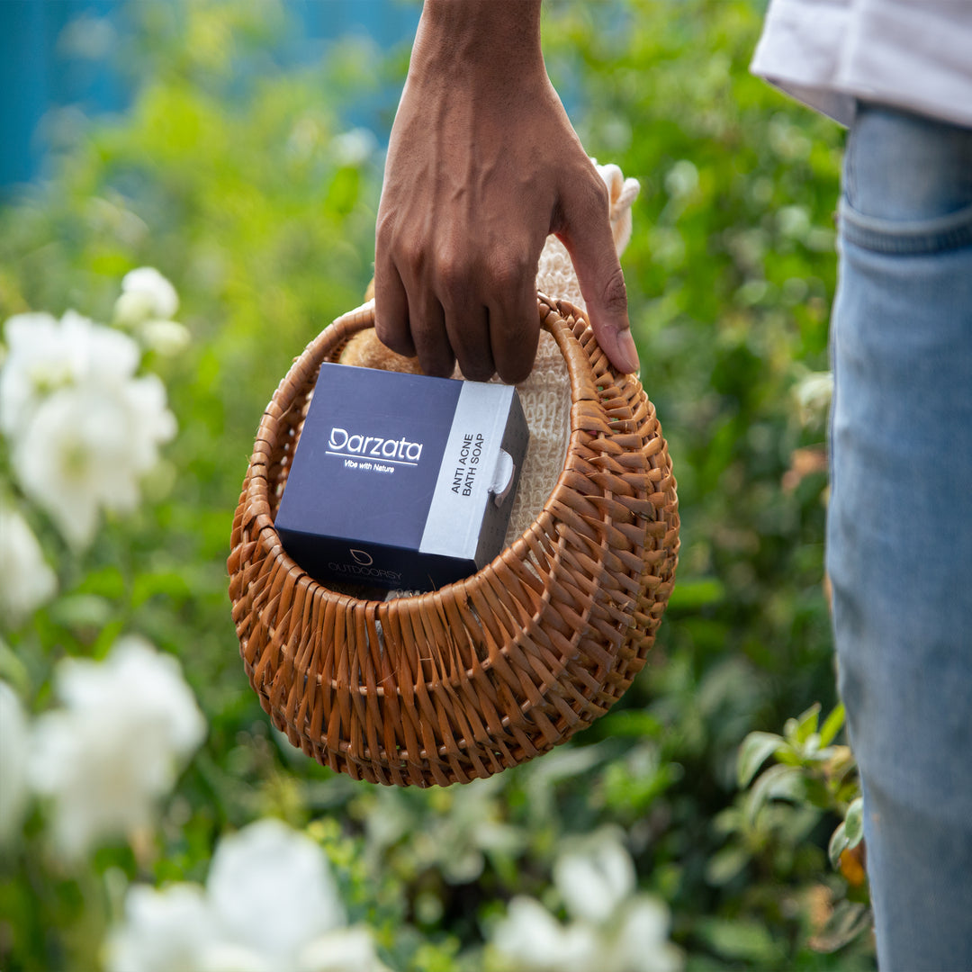 Man carrying Darzata charcoal soap in a basket outside